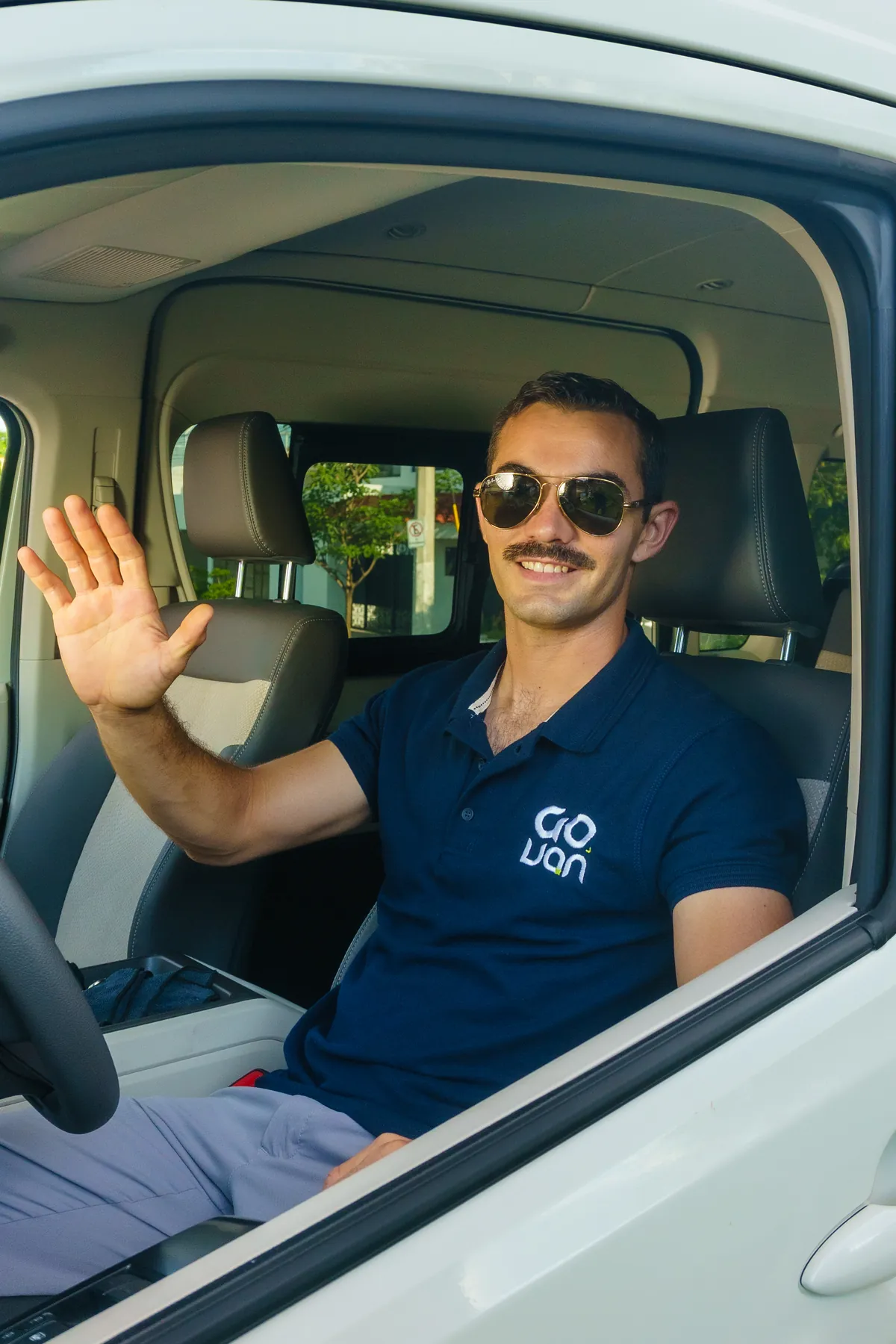 Chofer de GO VAN saludando desde la ventanilla